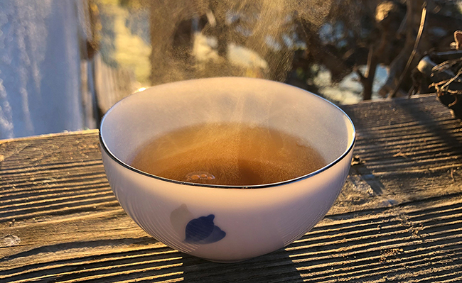 dampfende Teetasse auf Holzfensterbrett